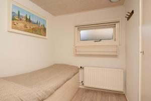 a bedroom with a bed and a window at Klein Doornroosje (gelegen op Doornroosje landgoed) in Ermelo