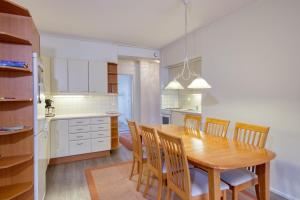 a kitchen and dining room with a wooden table and chairs at Tampereen kunkku in Tampere