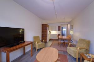 a living room with a television and a table and chairs at Tampereen kunkku in Tampere