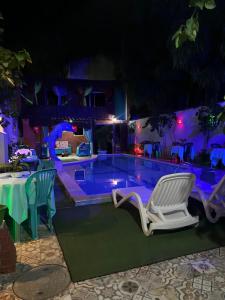 a swimming pool at night with chairs and a table at Ladeira de Olinda in Olinda