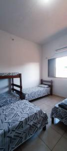 1 dormitorio con 2 camas y ventana en HOTEL JP, en Delfinópolis