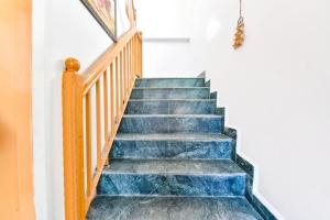 una escalera con escaleras de mármol azul y barandilla en FabHotel Elavali Valley, en Manali