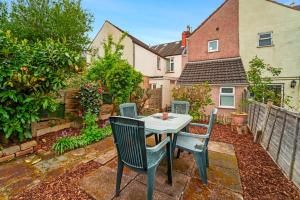 een patio met een tafel en stoelen in de achtertuin bij 4 Bed Homely Retreat - Wolverhampton in Wolverhampton