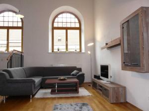 a living room with a couch and a tv at Kampenwand-Loft in Aschau im Chiemgau