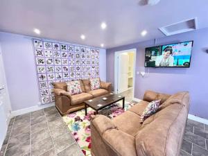 uma sala de estar com 2 sofás e uma televisão de ecrã plano em Accessible Couple Friendly Home Pass The Keys em Sketty