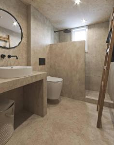 a bathroom with a sink and a toilet and a mirror at Olive Villa in Kamari