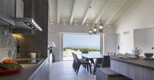 Una cocina y un comedor con mesa y sillas. en Villa Ylenia, en Argostoli