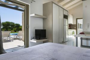 1 dormitorio con 1 cama, TV y patio en Villa Ylenia, en Argostoli