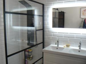 Un baño con lavabo y ducha de cristal. en Les Hauts de Carcès, en Carcès