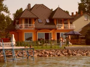 een vrouw die voor een huis op het water staat bij KATI VILLA-BEACH in Balatonlelle