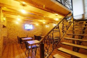 a restaurant with tables and chairs and a staircase at Friendship House in Tbilisi City