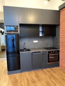 a kitchen with a black refrigerator and a sink at Kramare 303 in Bratislava