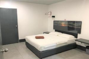 a bedroom with a bed with a large screen on the wall at Hotel Ventura in Kangar