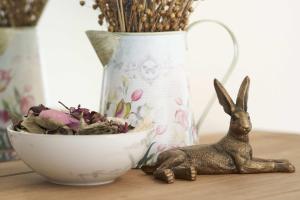a small statue of a rabbit next to a bowl of flowers at The White Hart Hotel in Modbury