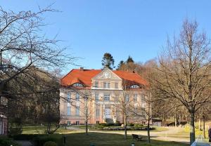 a large building with an orange roof in a park at Ferienwohnung Sonne in Neddesitz +46 photos