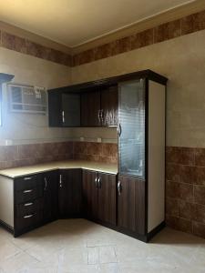 a kitchen with wooden cabinets and a counter top at طيبة الطيبة in Al Madinah