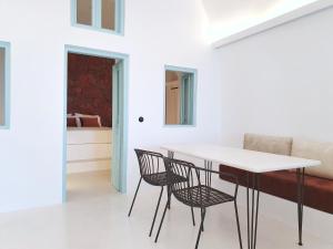 a dining room with a white table and chairs at Sun Spell Villa - with private hot tub up to 6 pax in Fira