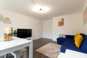 uma sala de estar com um sofá azul e uma televisão em Great prices on long stays!-Luna Apartments Washington em Washington