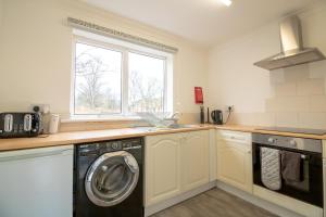 a kitchen with a washing machine and a window at Great prices on long stays!-Luna Apartments Washington in Washington