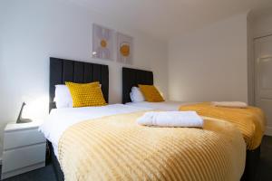 sypialnia z 2 łóżkami z żółtą i białą pościelą w obiekcie Great prices on long stays!-Luna Apartments Washington w mieście Washington