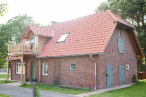 ein rotes Backsteinhaus mit Balkon darauf in der Unterkunft Haus am Holder in Böhme