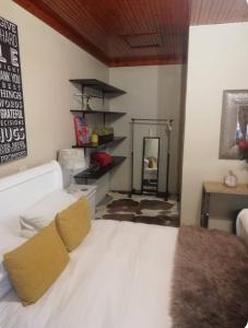 a bedroom with a white bed and a mirror at Shai's Studio in Centurion