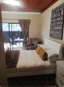 a bedroom with a large bed and a living room at Shai's Studio in Centurion