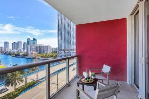 a balcony with a red wall and a table and chairs at Spectacular Balcony - Near Beach - Gym - Pool in Hallandale Beach