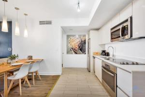 a kitchen with white cabinets and a table and chairs at Spectacular Balcony - Near Beach - Gym - Pool in Hallandale Beach