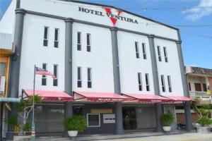 un gran edificio blanco con un hotel con bandera en Hotel Ventura, en Kangar