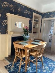 a dining room with a wooden table and chairs at Signalman's Cottage in Clachnaharry in South Kessock