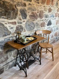 a wooden table with a tray of food and a chair at Signalman's Cottage in Clachnaharry in South Kessock