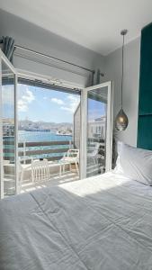 una camera con letto e vista sull'oceano di DIIO Suites a Ermoupoli