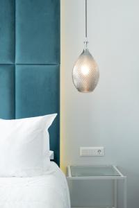 a bedroom with a bed and a pendant light at DIIO Suites in Ermoupoli