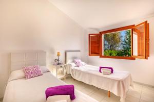 two beds in a room with a window at Beach Villa Can Carles by Sealand Villas in Port de Pollensa +19 photos