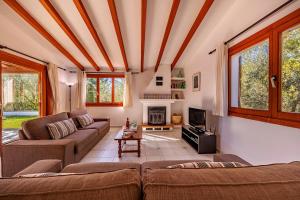 a living room with a couch and a fireplace at Beach Villa Can Carles by Sealand Villas in Port de Pollensa