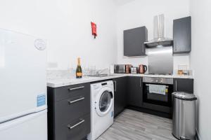 a kitchen with a washing machine and a washer at Stylish Brierley Hill - 1 Bed Apt - Free Parking - Netflix & Wifi - 305O in Brettell Lane