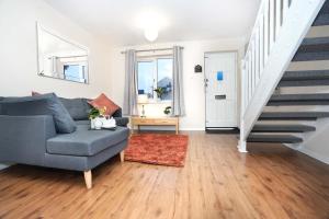 a living room with a blue couch and stairs at Lummis Vale in Ipswich