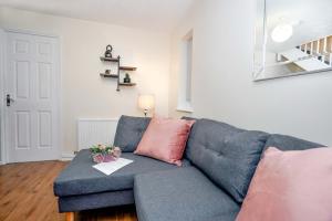salon z niebieską kanapą i różowymi poduszkami w obiekcie Lummis Vale w mieście Ipswich