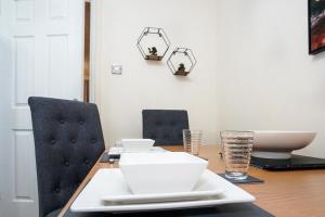 stół jadalny z 2 krzesłami i białymi talerzami w obiekcie Lummis Vale w mieście Ipswich