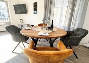 einen Esstisch mit Stühlen und Weingläsern in der Unterkunft Exklusive Wohnung mit Ahrblick 2, Balkon und 2 Schlafzimmer in Bad Neuenahr-Ahrweiler