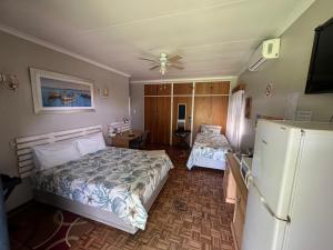 a bedroom with two beds and a refrigerator at The Lighthouse Guesthouse in Welkom