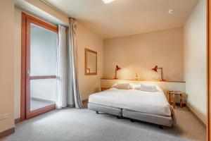 a bedroom with a bed and a large window at Albergo Sorriso in Boario Terme