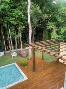 eine Holzterrasse mit einem Pool im Hof in der Unterkunft Casa 05 suítes, piscina e natureza in Mata de Sao Joao