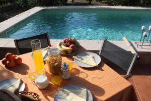 a table with food and fruit on it next to a swimming pool at Villa Ana in Sóller