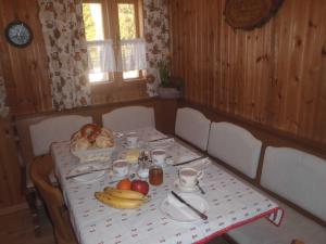 una mesa con plátanos y una cesta de frutas. en Wildererhütte 240 Jahre alt 