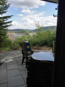 un patio con mesa y sillas y vistas al río en Dreimal Seeblick, en Bringhausen