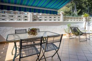 una mesa de cristal y sillas en un patio en AT052 Planta baja con piscina, tan solo 600m de la playa, en Torredembarra