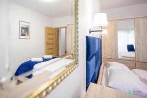 um pequeno quarto com um espelho e uma cama em Apartament Gambit, Ogrody Pieniawskie, MyWeek em Polanica-Zdrój