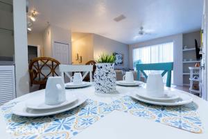 a dining room with a table with plates on it at Incredible apartment just 15 minutes from Disney in Kissimmee